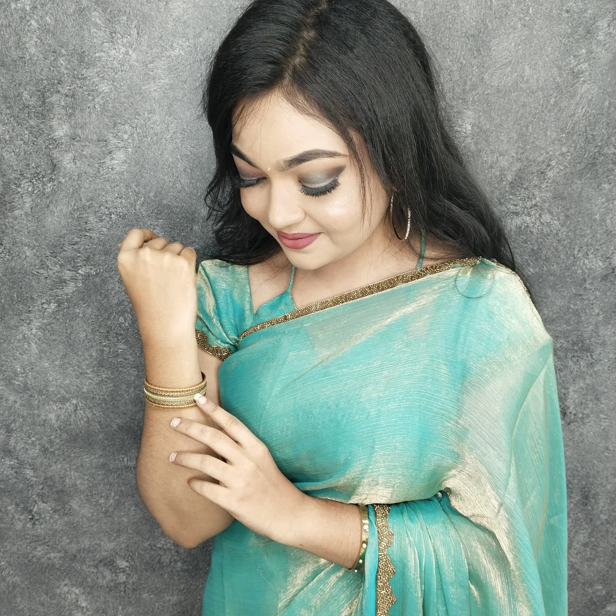Traditional South Indian bridal makeup with dramatic eyes, red lips, and gold temple jewelry